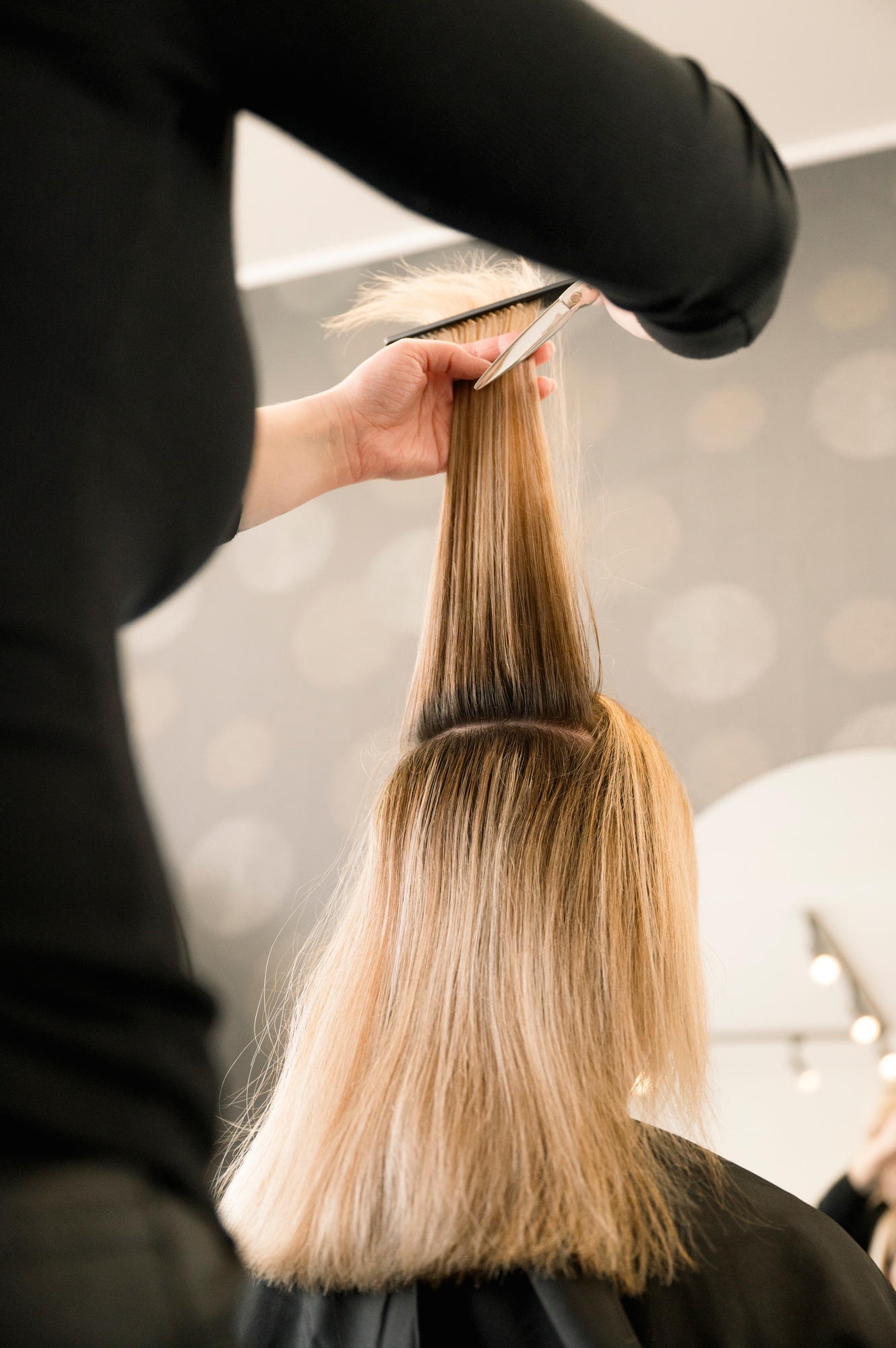 Professional hairdresser cutting woman's hair in salon, closeup